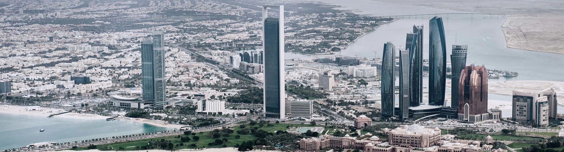 Panorama von Abu Dhabis Stadtzentrum mit einem klaren Blick auf Wolkenkratzer und Wüste im Hintergrund.