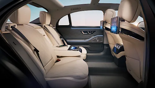 Interior shot of the back seat of a First Class Blacklane limo. showing leather seats and screens. 