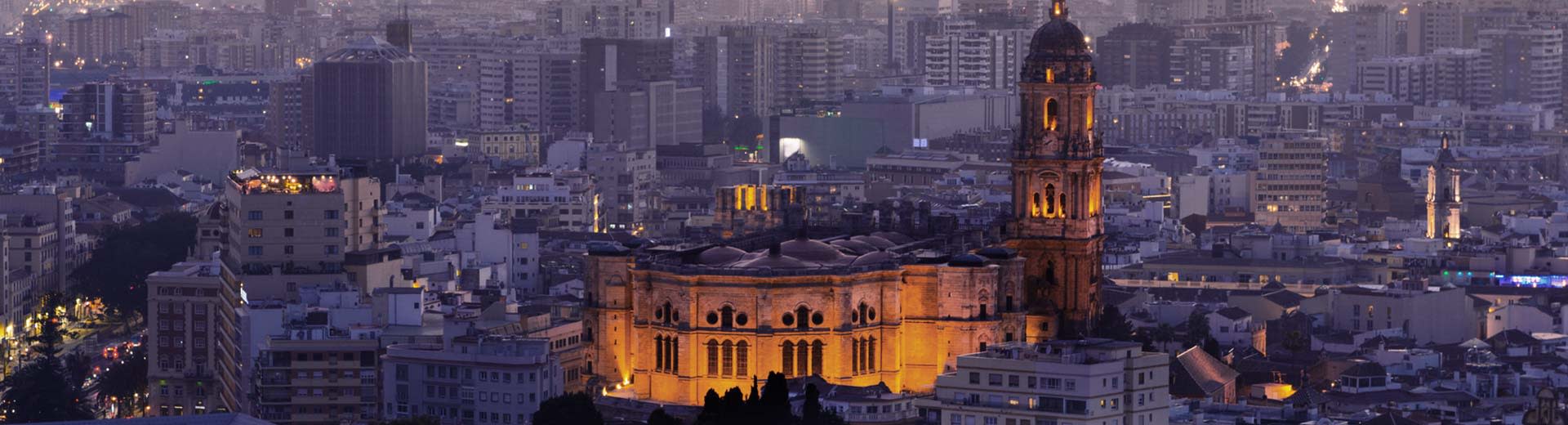 The beautiful, historic city center of Malaga in the half-light of dusk.