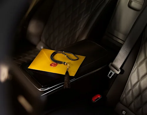 Some prayer beads in the back seat of a luxury car.