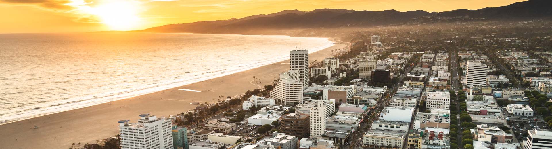 Beautiful Santa Monica during dusk or dawn, with the Pacific Ocean gently lapping the shore.