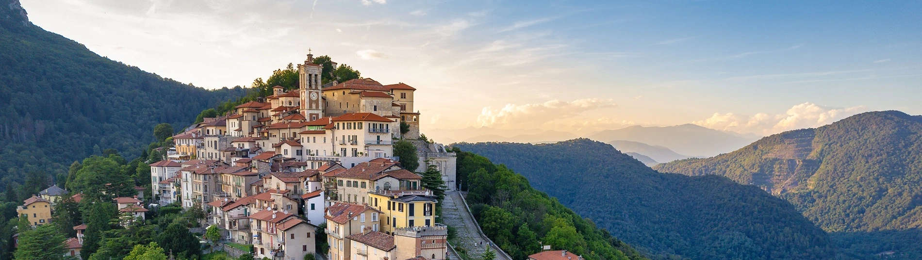 The hilltop town of Santa Maria del Monte on the Sacro Monte di Varese in Italy, with the sun setting in the background.