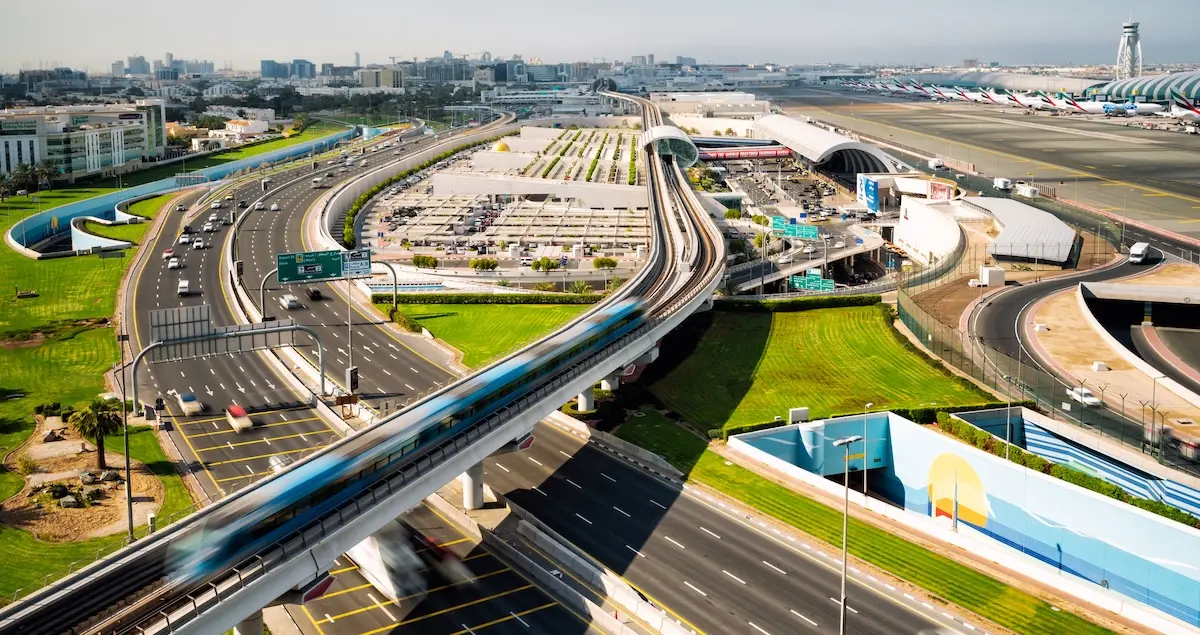 Aerial shot of the motorways around Dubai International Airport and metro track at sunny day.