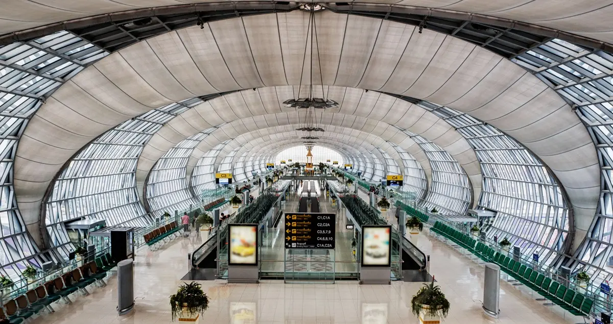 Interior shot of Terminal E in Bangkok Airport, displaying the central walkway and its eye-catching glass windows.