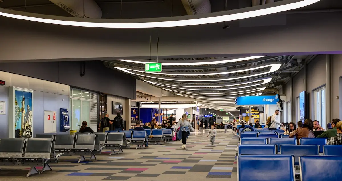 Departure hall of Athens International Airport Eleftherios Venizelos showing seating and people waiting.