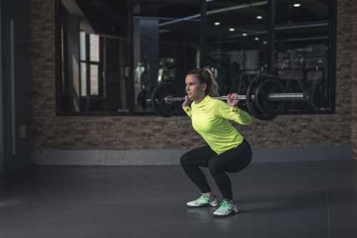 A women using weights to squat during her gym workout
