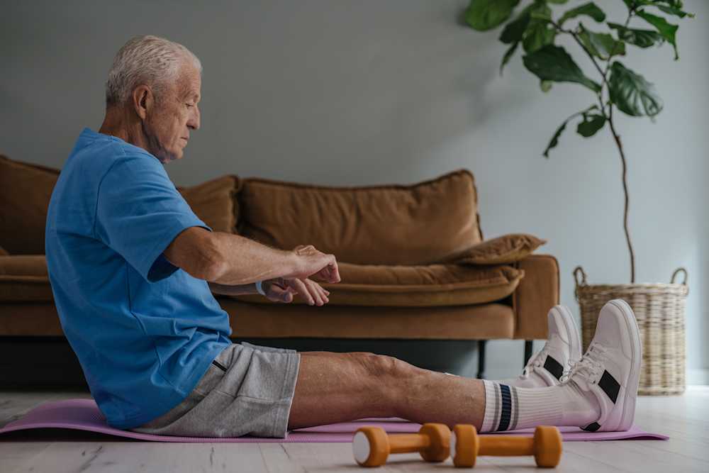 An elderly man doing exercise and stretches within his home