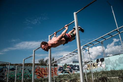calisthenics workout, personal trainer hanging off a pole