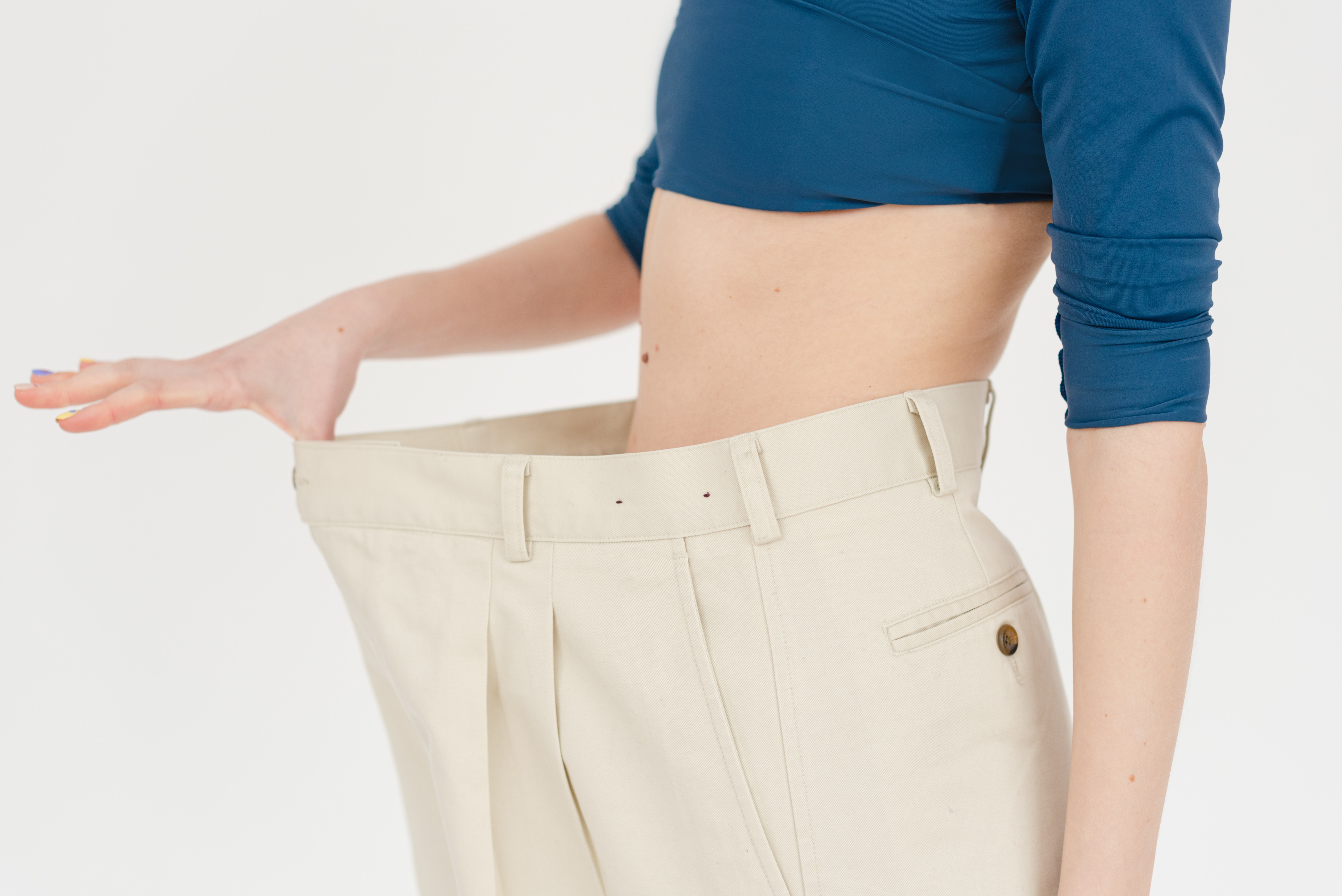 Woman showing off weight she has lost in trousers that are now too large