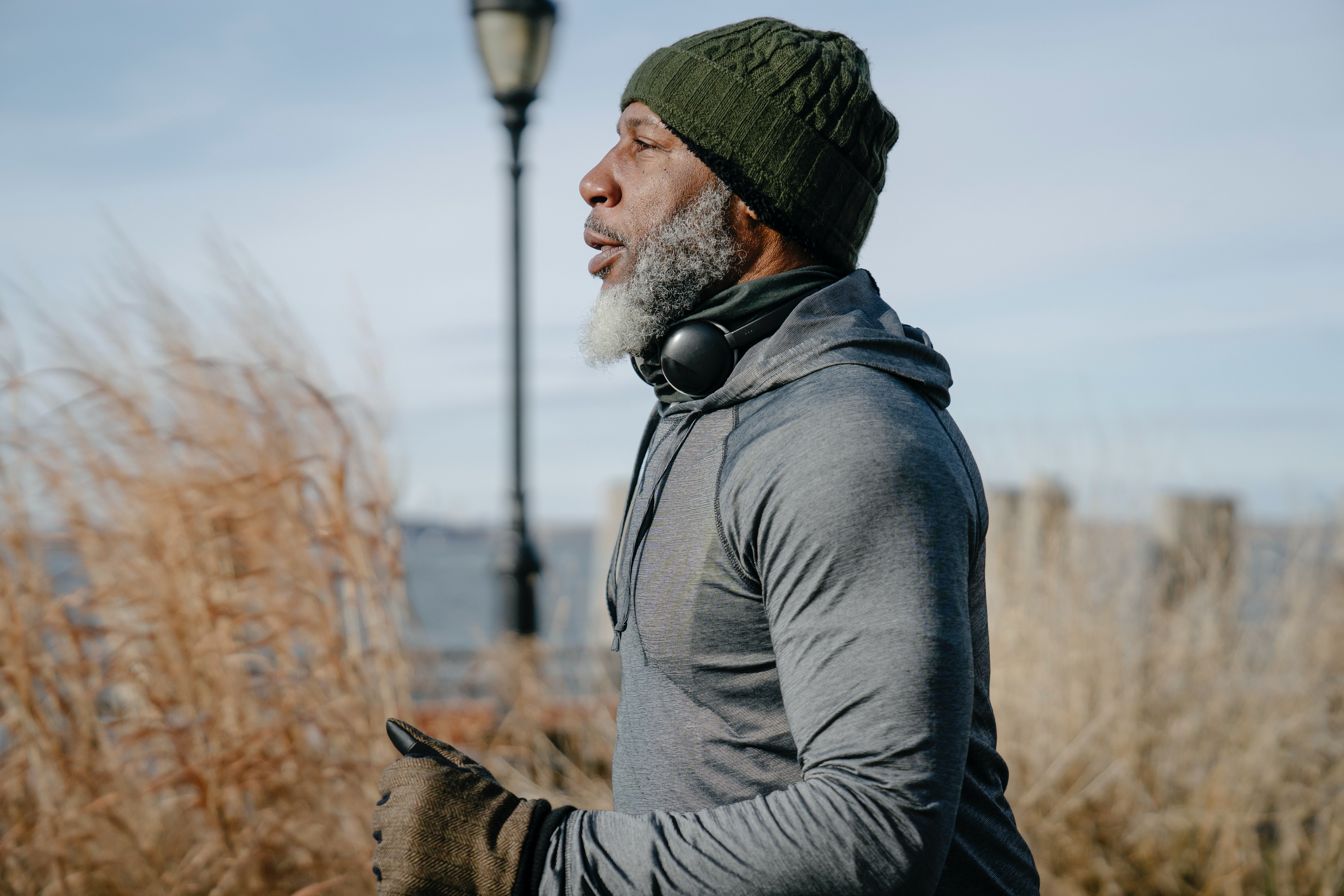 Older gentleman running next to road for fitness