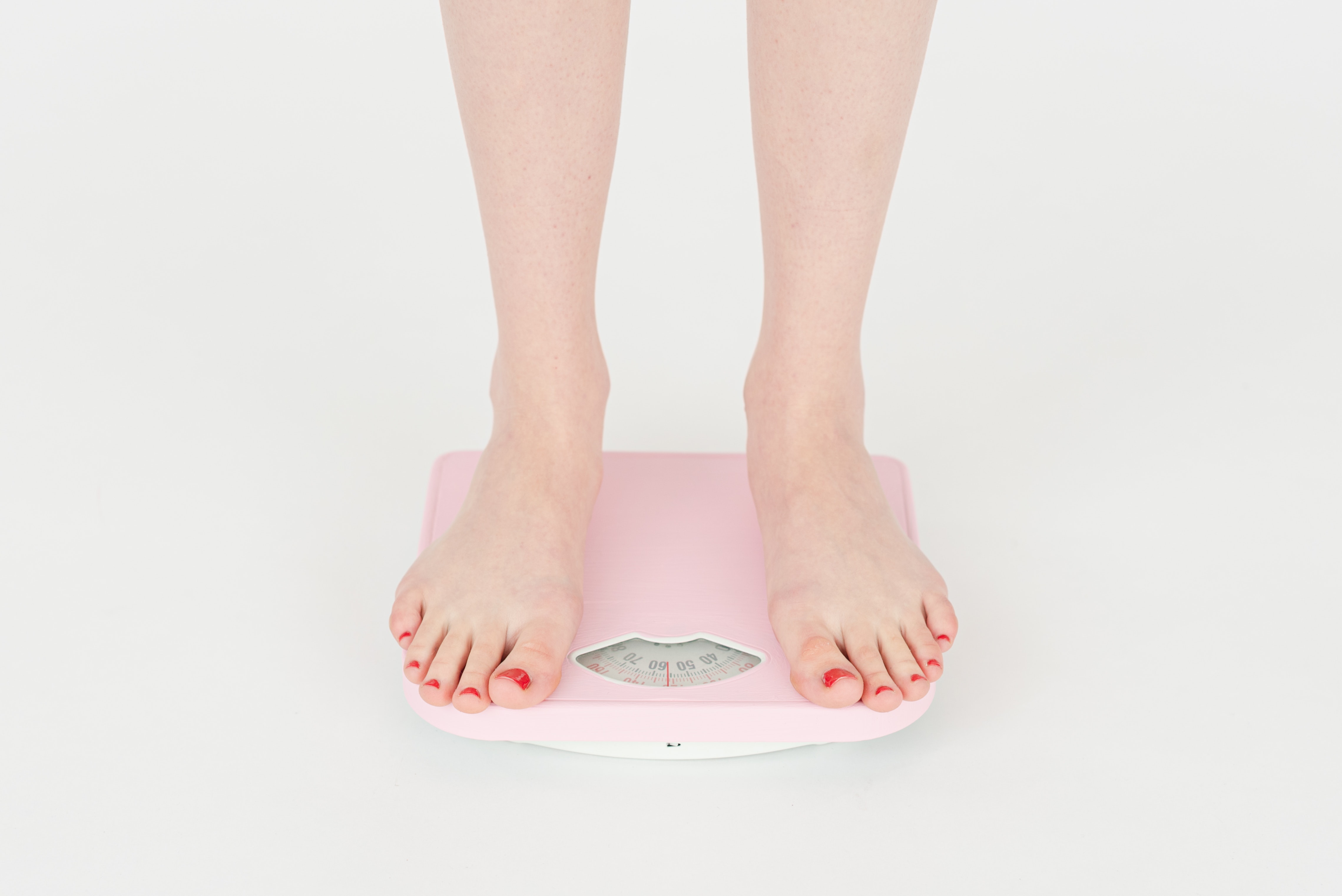 Woman standing on scales hoping for weight loss result