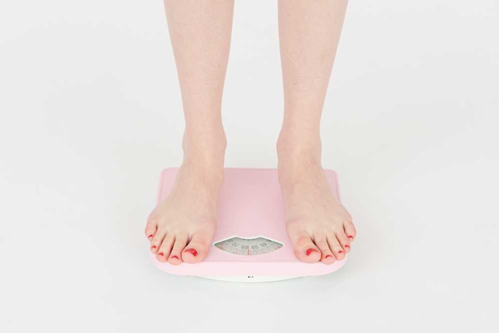 Woman standing on scales hoping for weight loss result