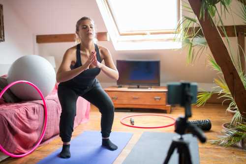 A women working out in her own home on video with her online personal trainer.
