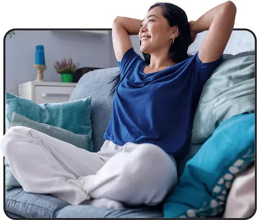 Smiling woman relaxing on a sofa with her hands behind her head