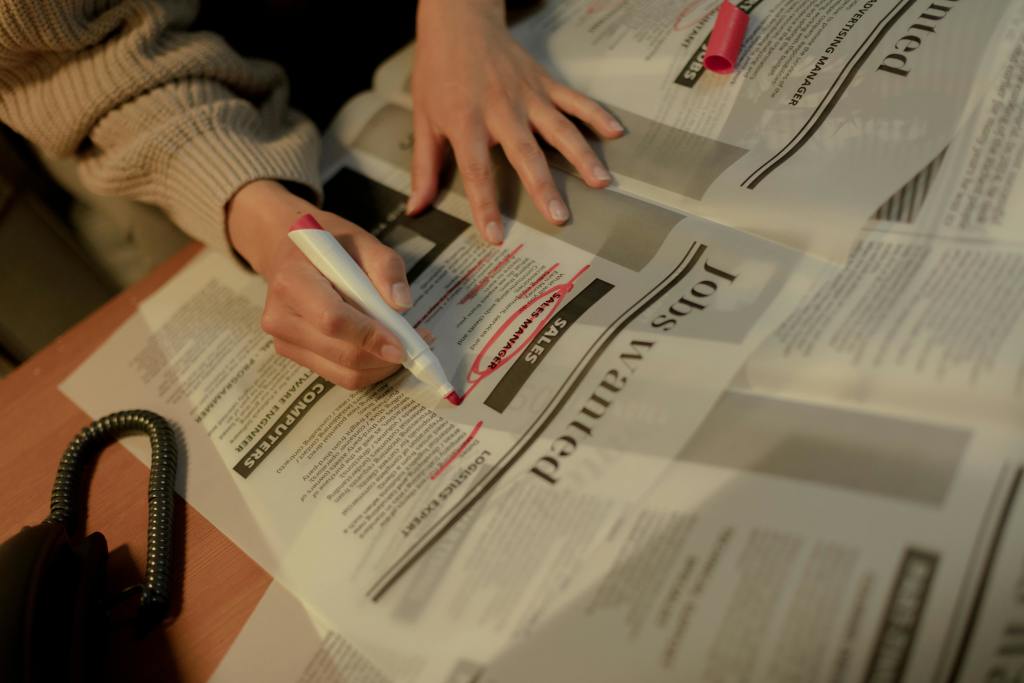 A person highlighting jobs on a newspaper