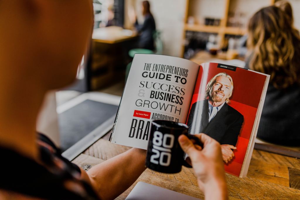 A man reading success to business growth magazine while holding a mug