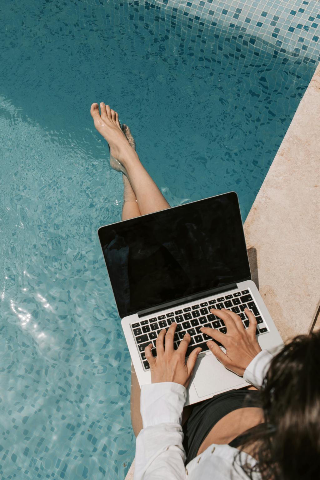 A woman working remotely by the pool