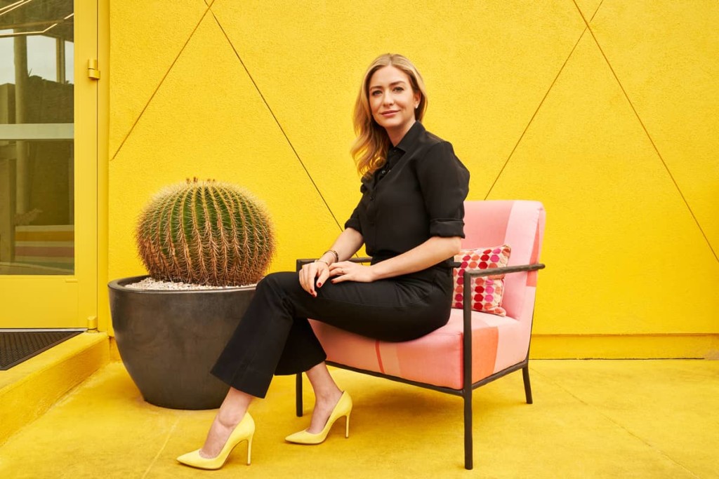 Woman sitting on a couch in a vibrant yellow background