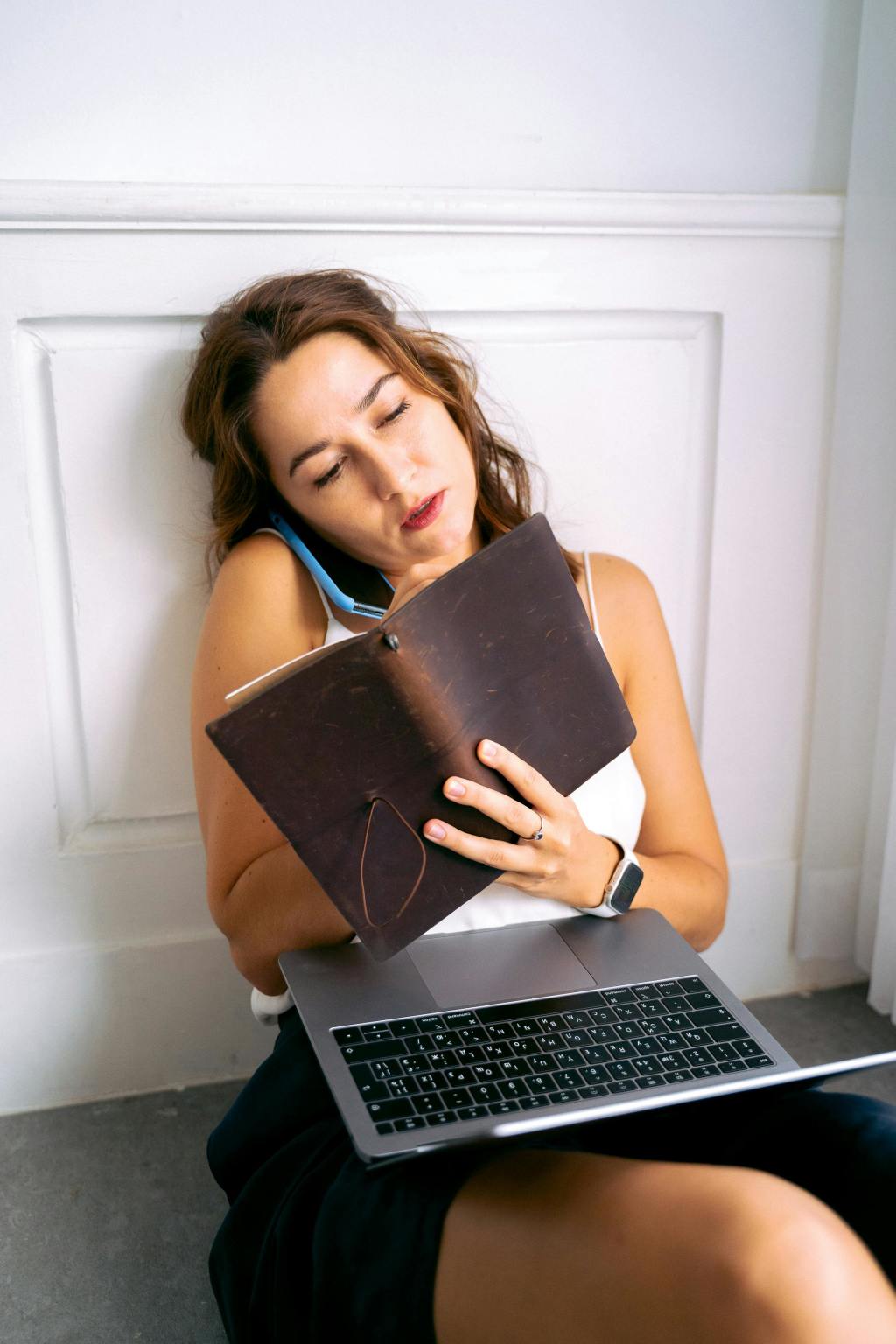 Woman talking on her phone while reading her notebook