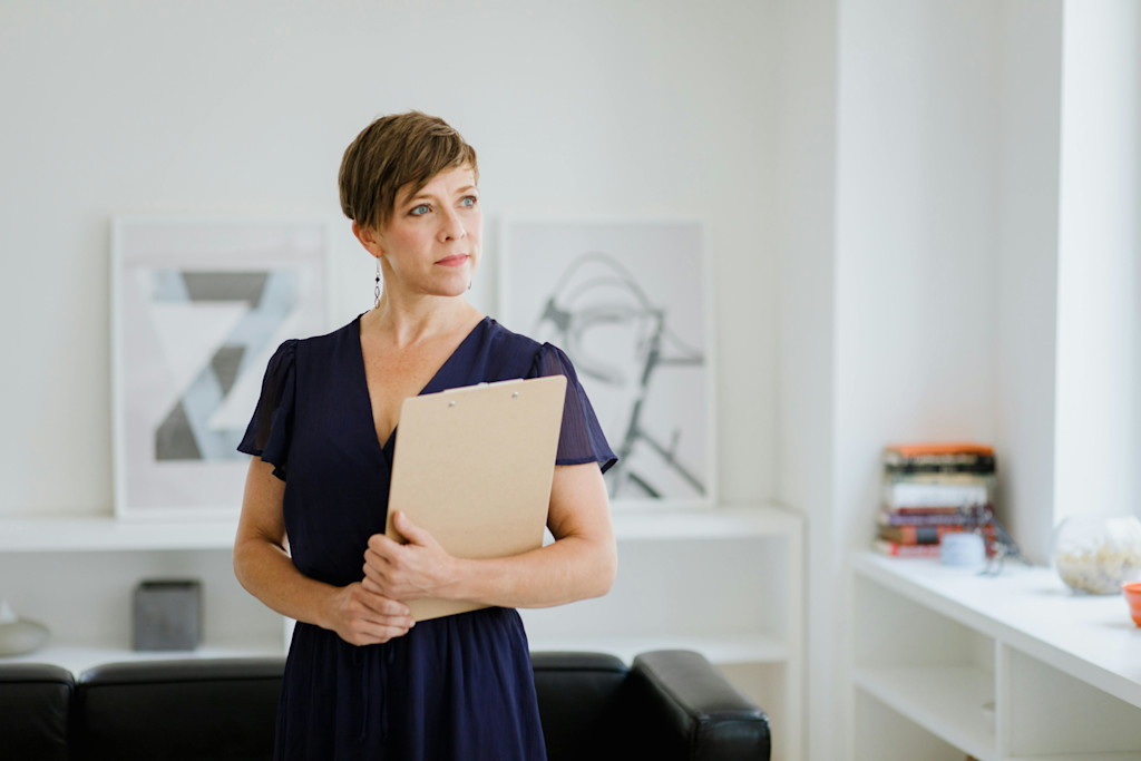 A woman standing holding a folder