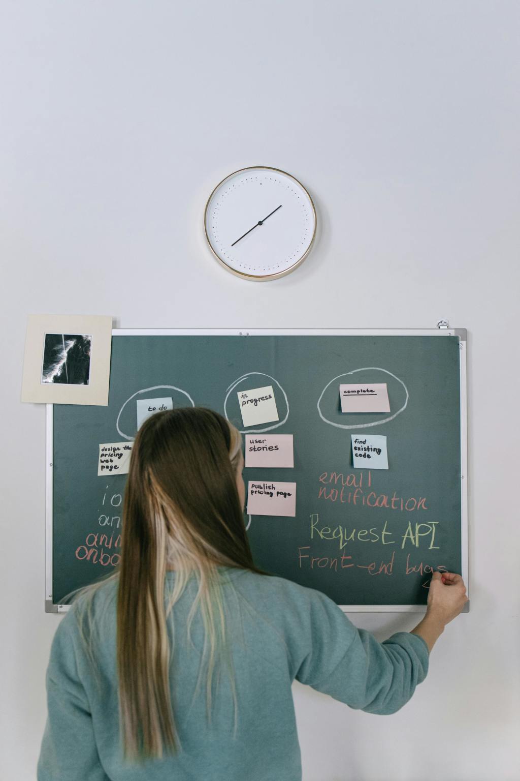 A woman writing notes on a blackboard