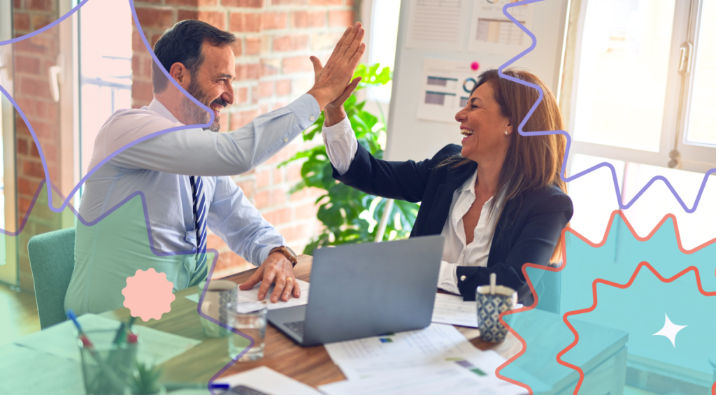 A man and a woman doing a high five inside an office setting