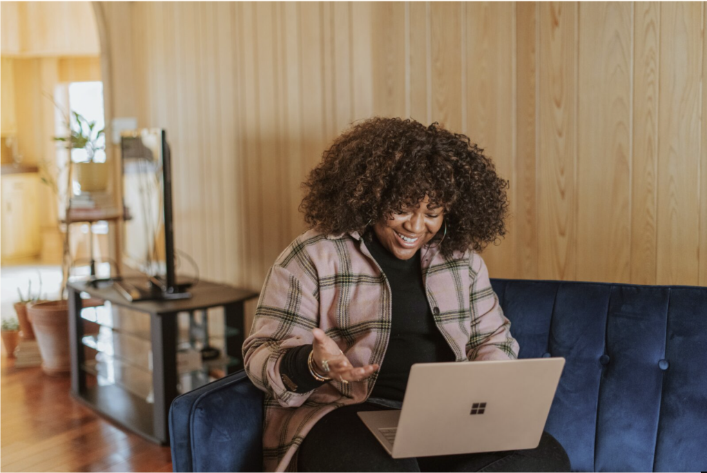 Woman working on her laptop with a big smile on her face