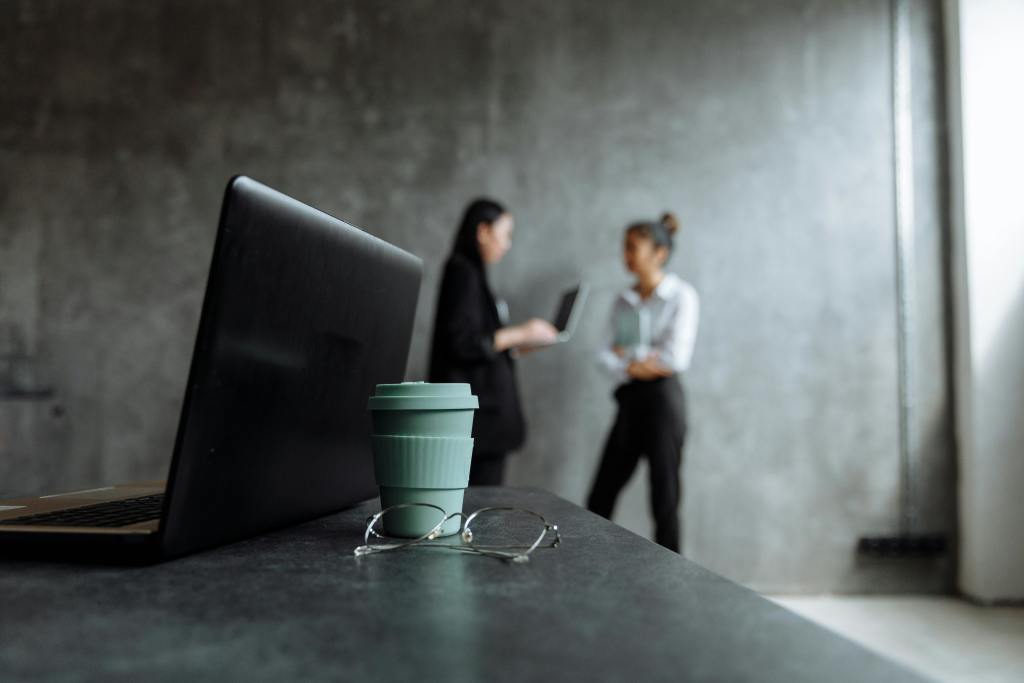 A picture of a coffee cup with 2 women talking in the background