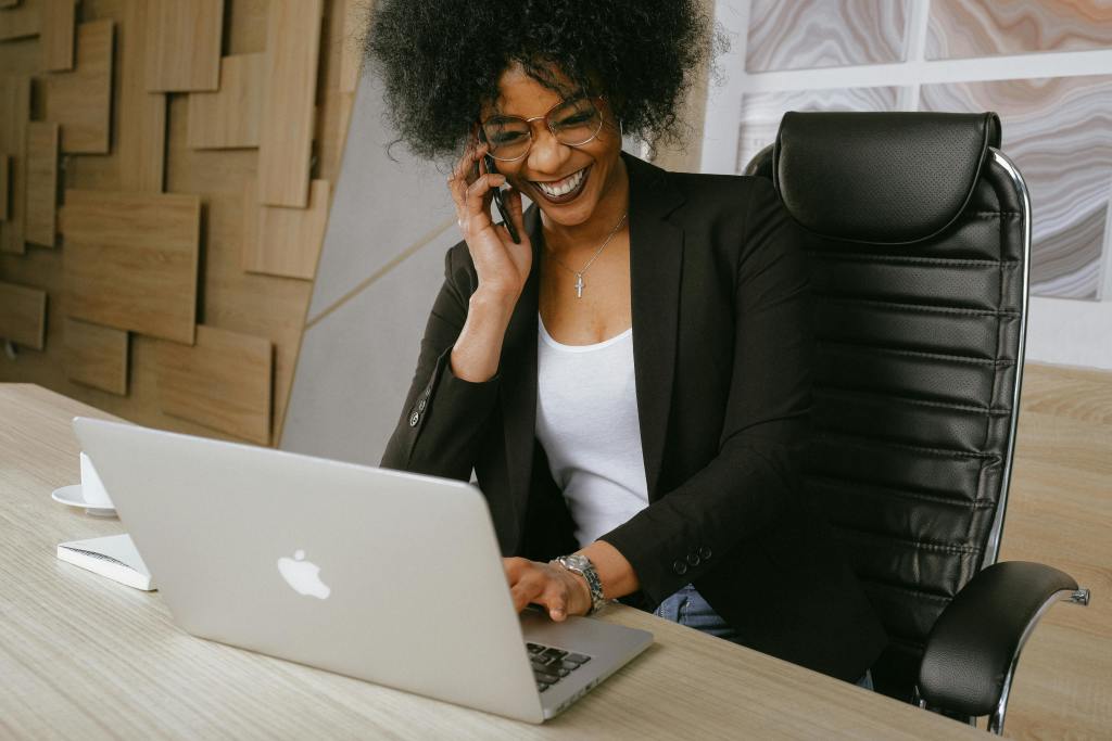 A woman talking to a client on the phone with a smile on her face