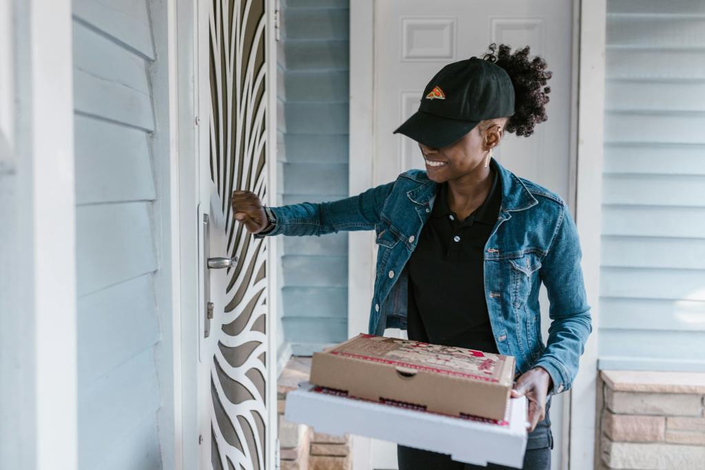 A pizza delivery personnel knocking on the door