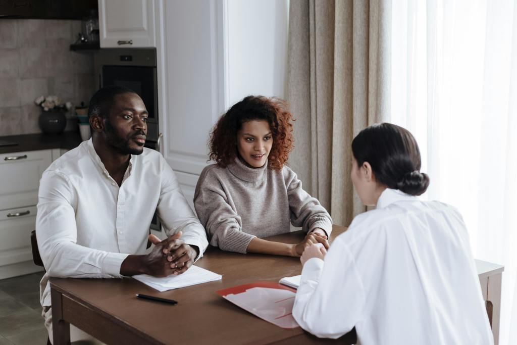 Two people talking to a woman in an interview