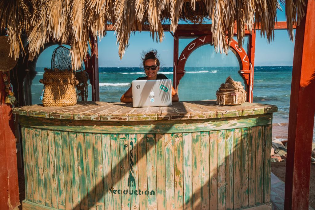 Woman working remotely in a beach location