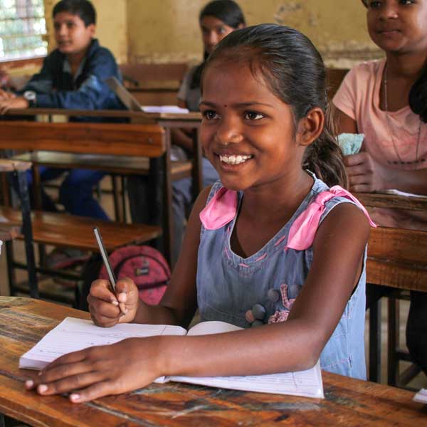 female child writing in classroom