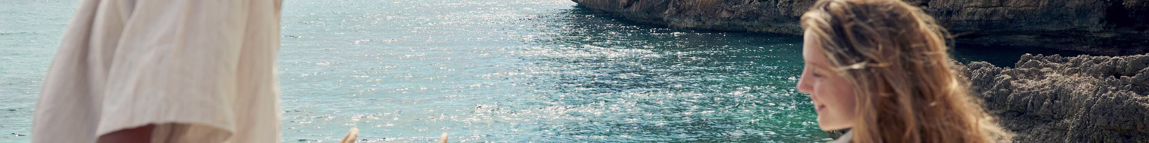 Young women sunbathing by the sea cliffs