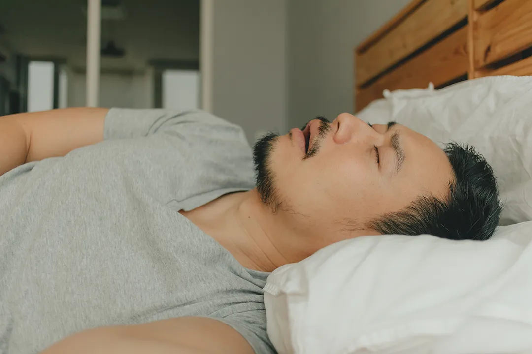 Man Sleeping On Back In Bed