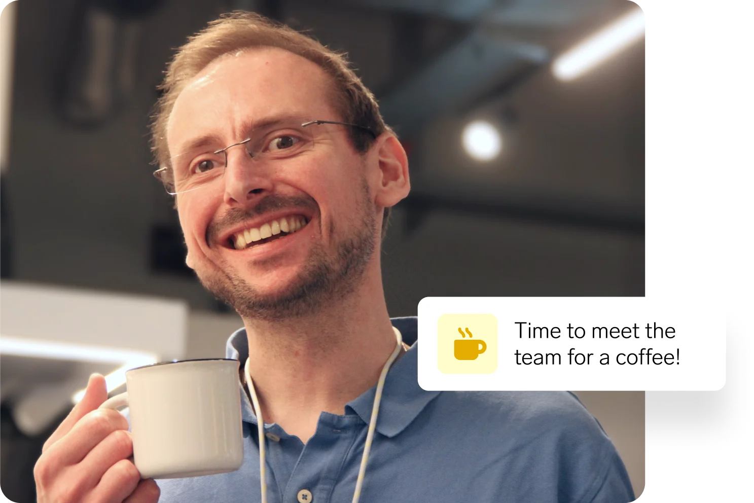 Man in Data smiling while holding a coffee mug