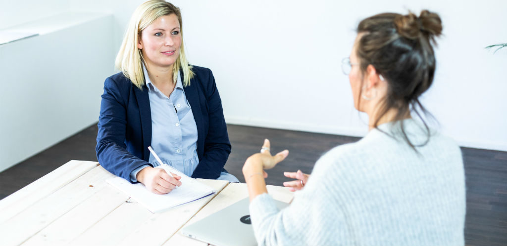 Personalerin spricht mit Mitarbeiterin über Abfindung.