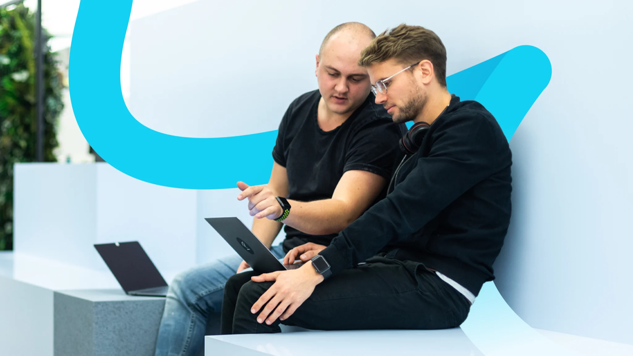 Two men looking at a laptop, product showcase