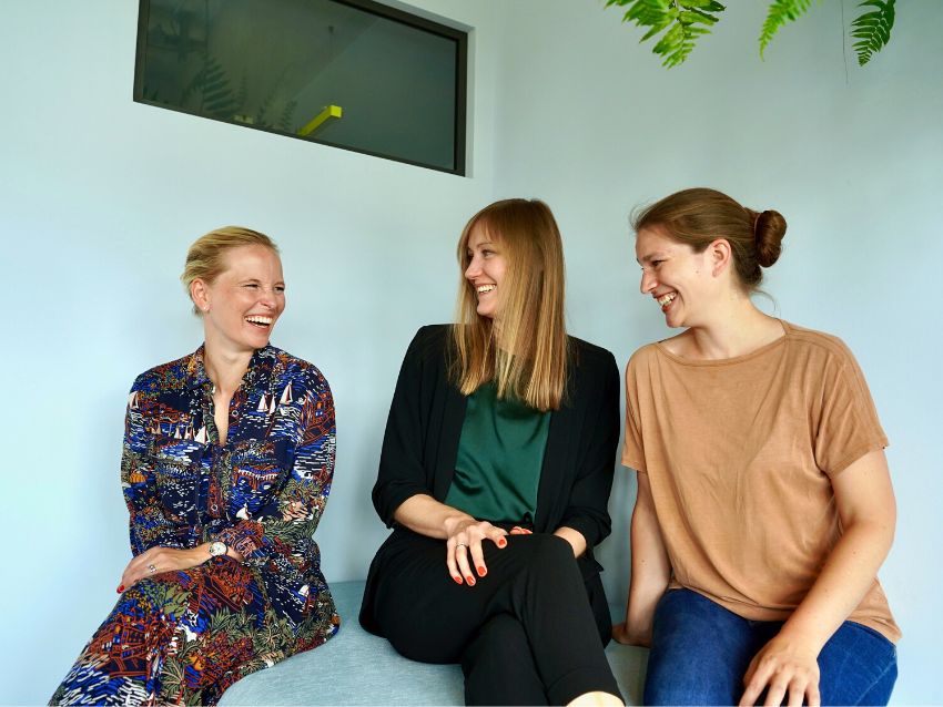 Three women smiling at each other