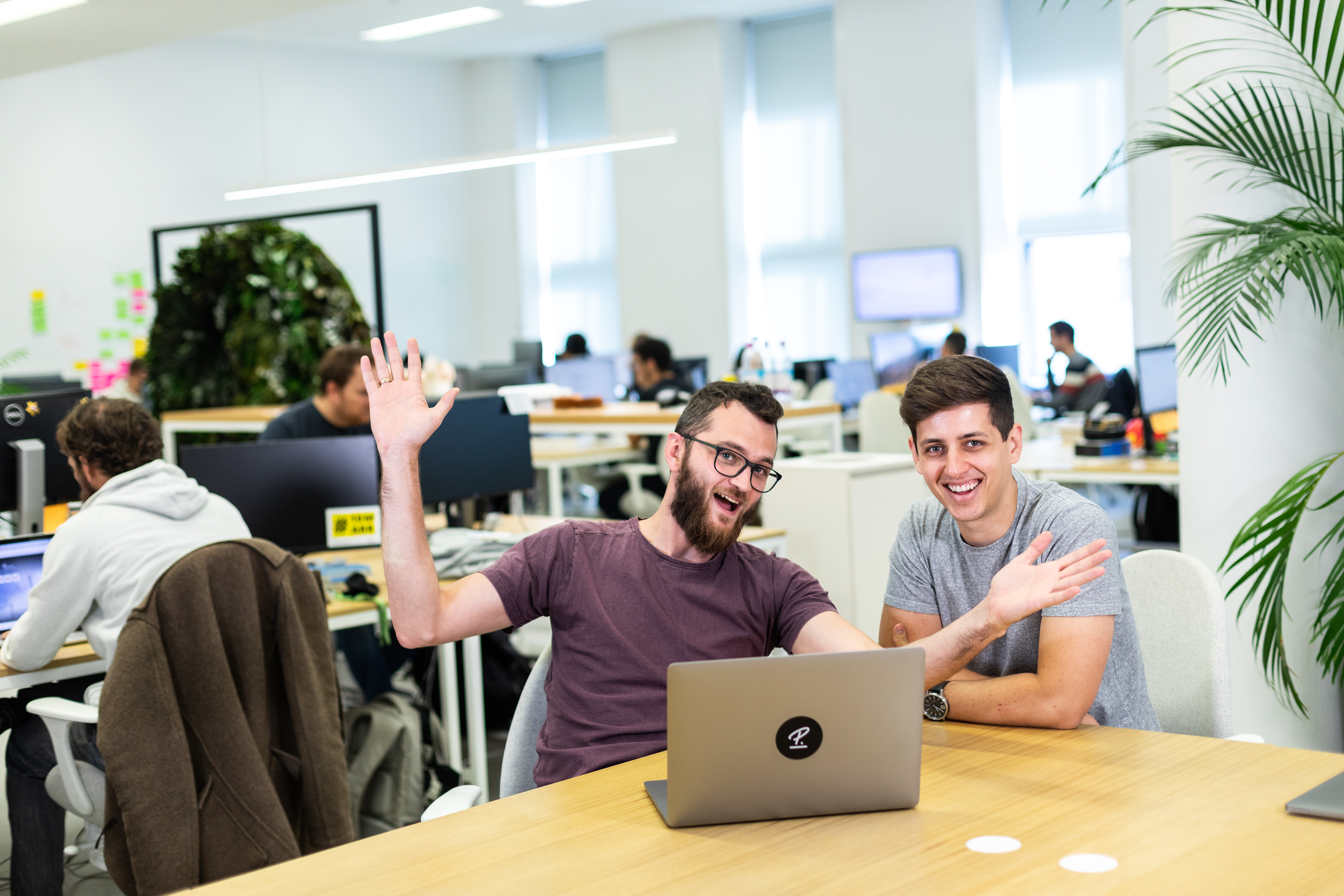 2 People smiling behind laptop