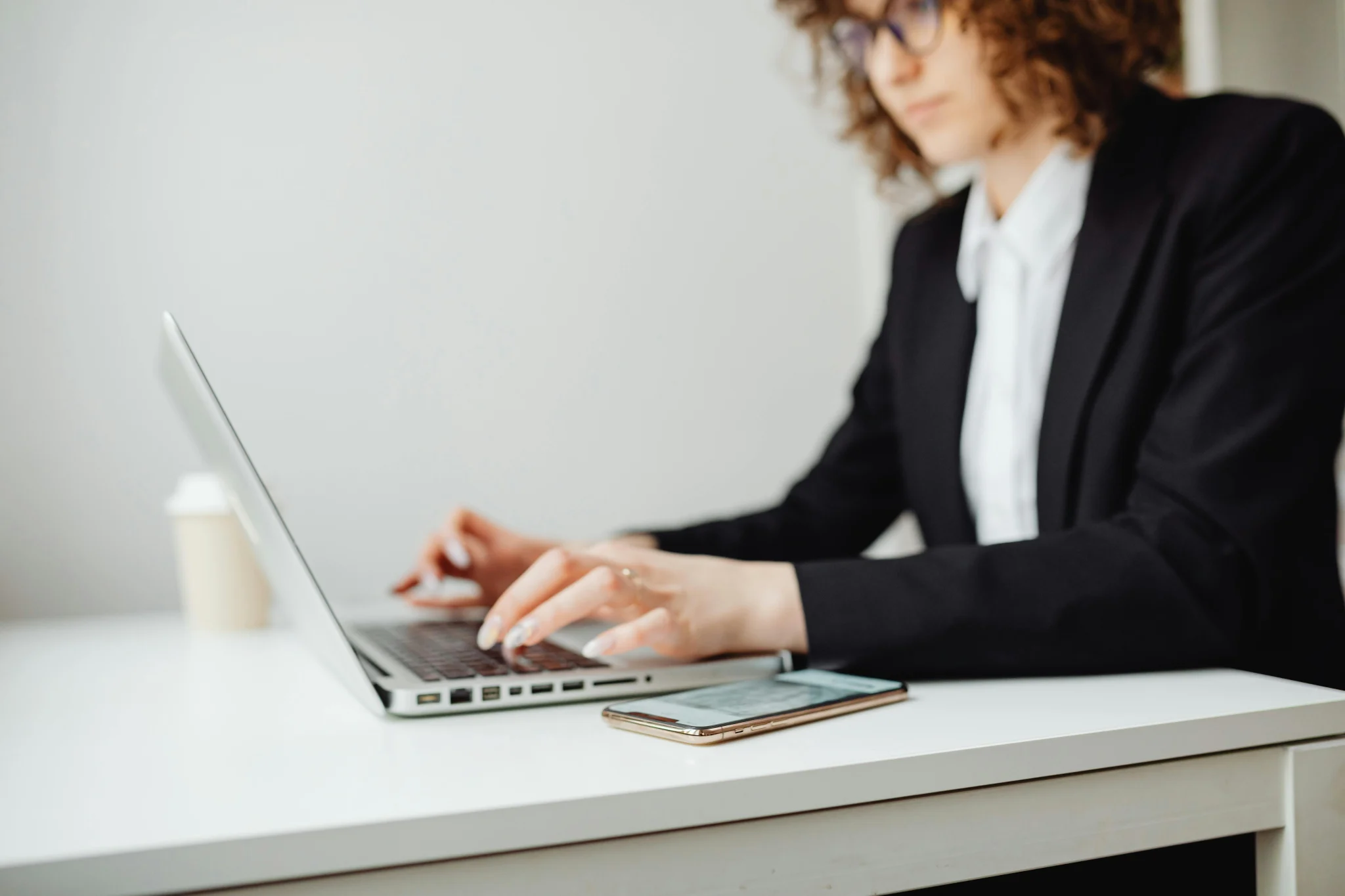 Woman in black suit writing an e-mail