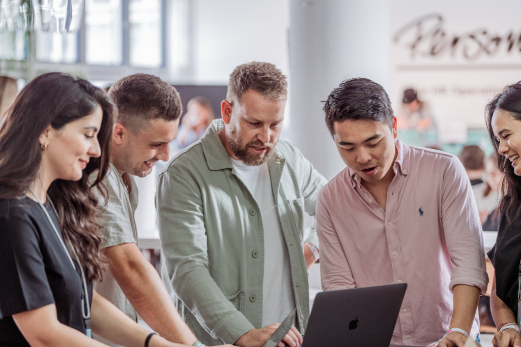 5 people standing in a group working