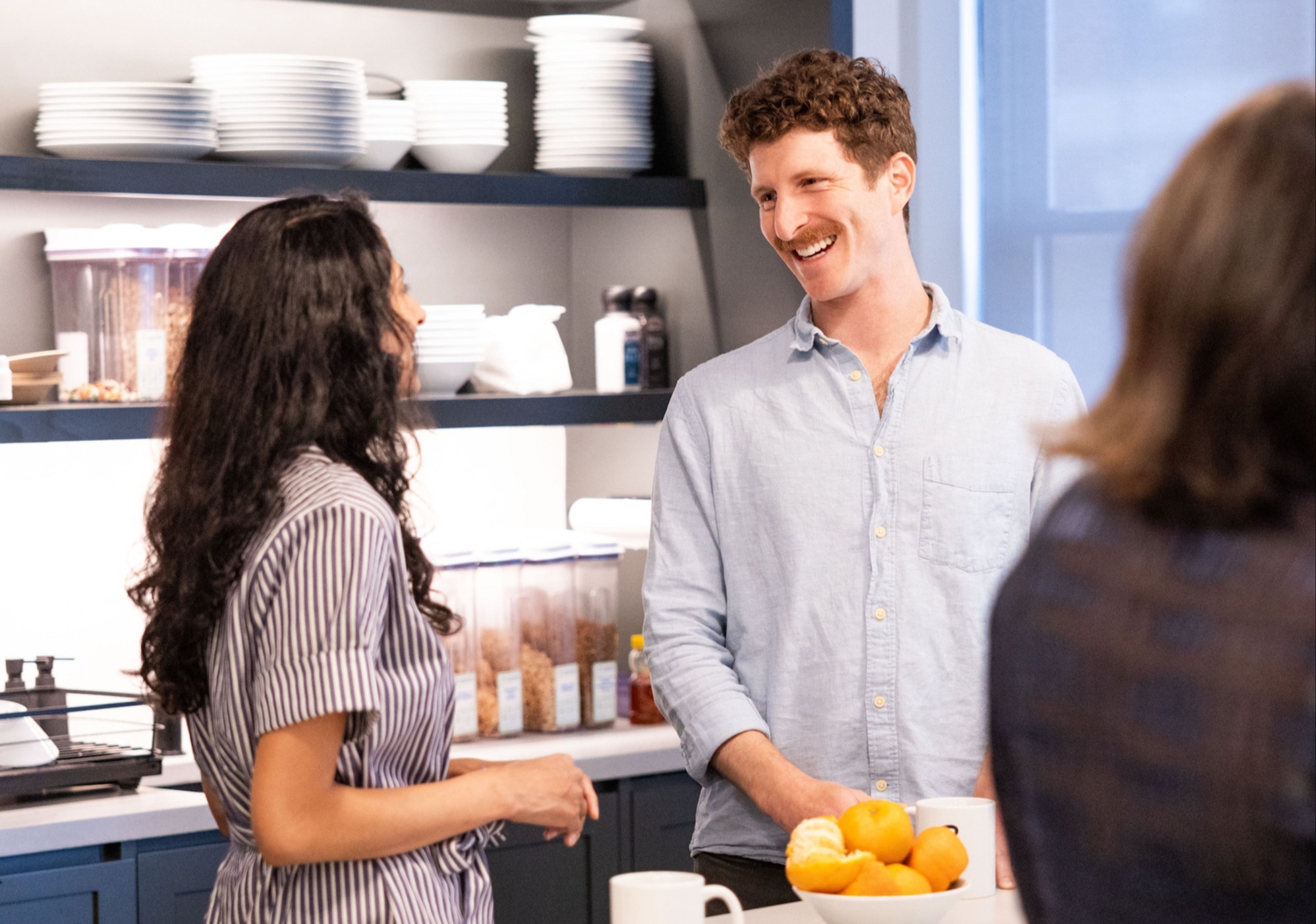 (PWI Rebrand Title) Co-workers talking in kitchen