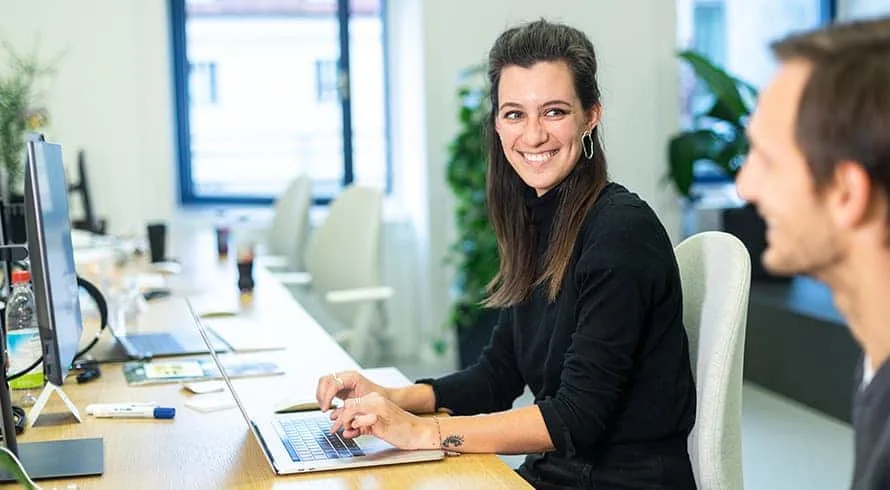 Smiling employee working on laptop