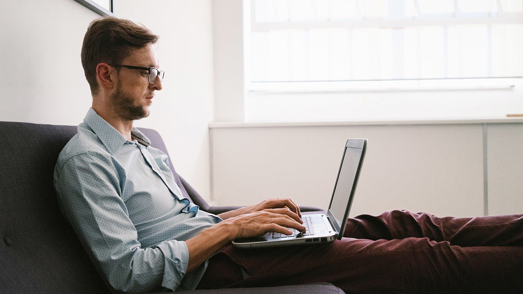 Home Office - Mann arbeitet von Sofa aus