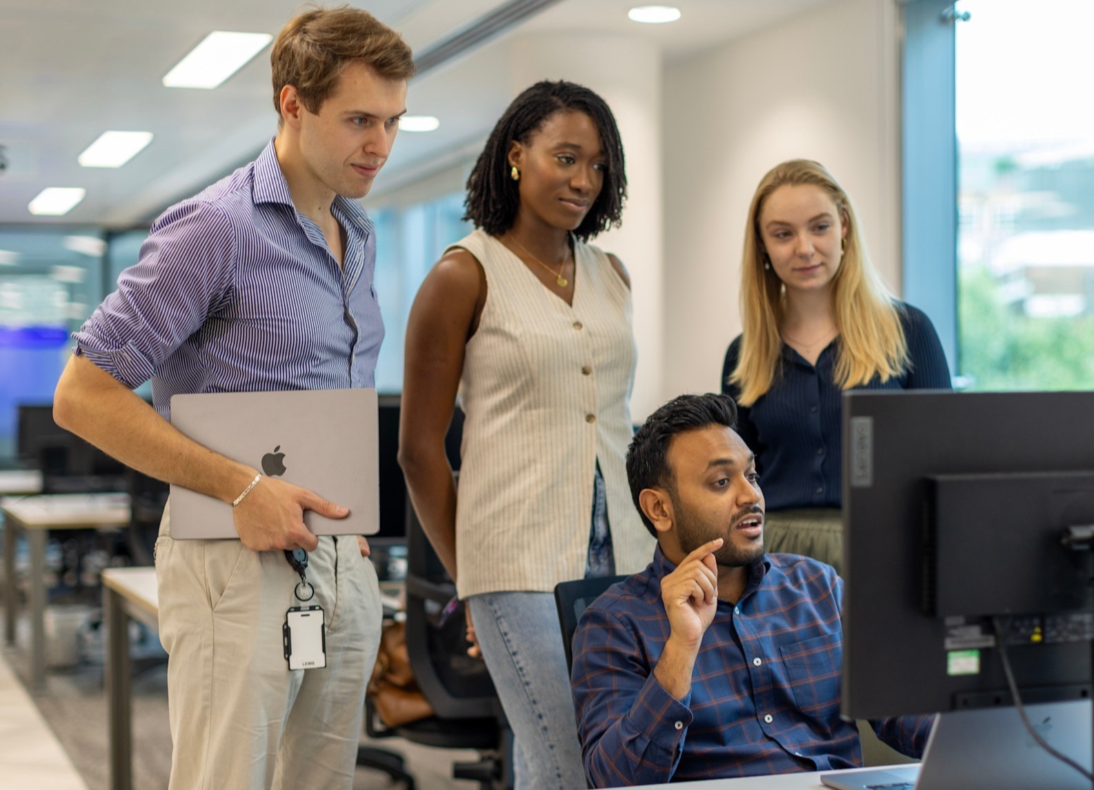 4 people looking at laptop