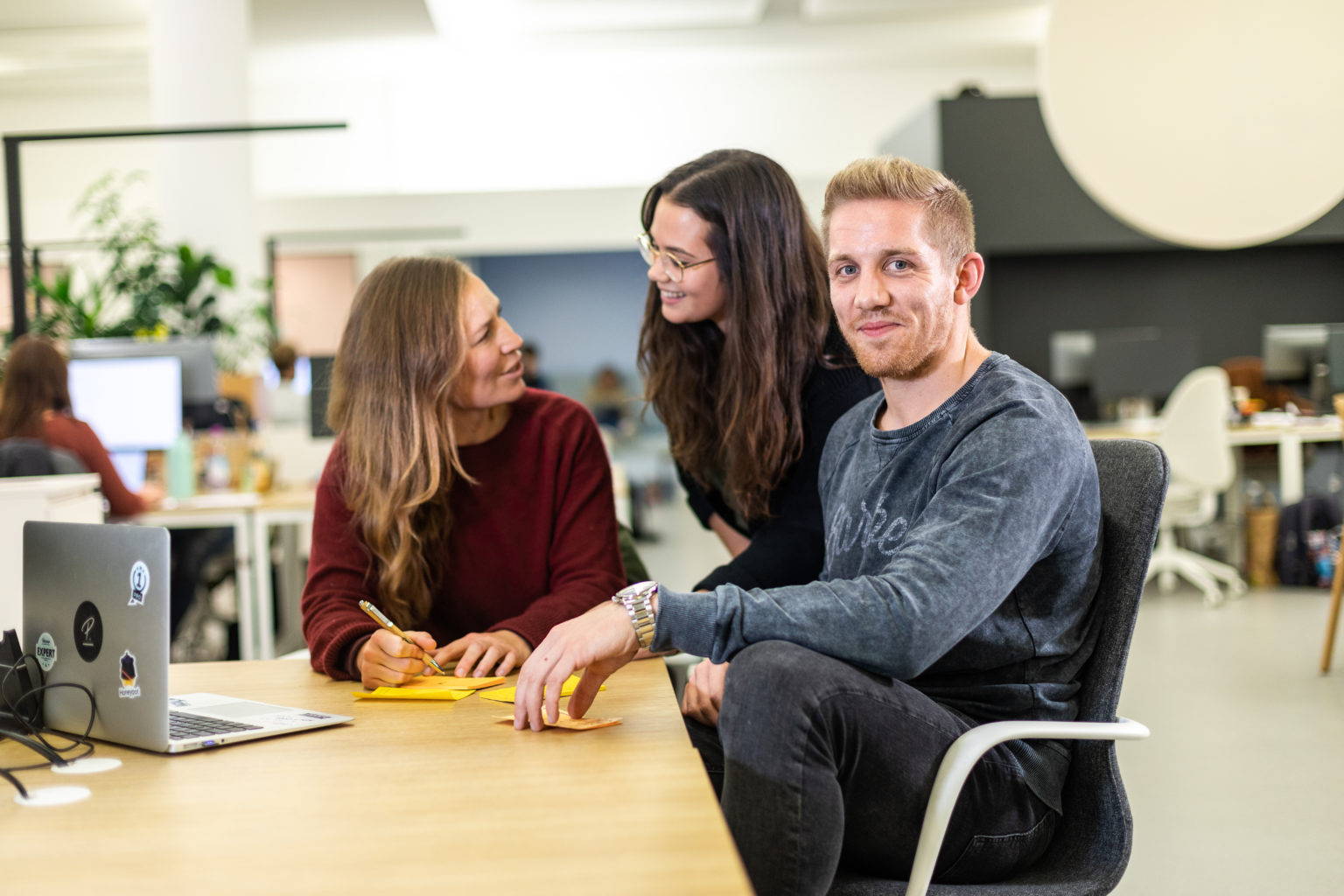 3 people sitting in an office having a chat