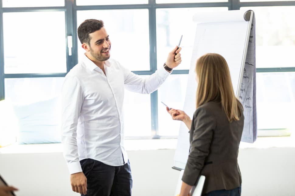 Mitarbeiter stehen vor einem Flipchart