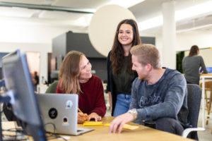 3 people smiling while working