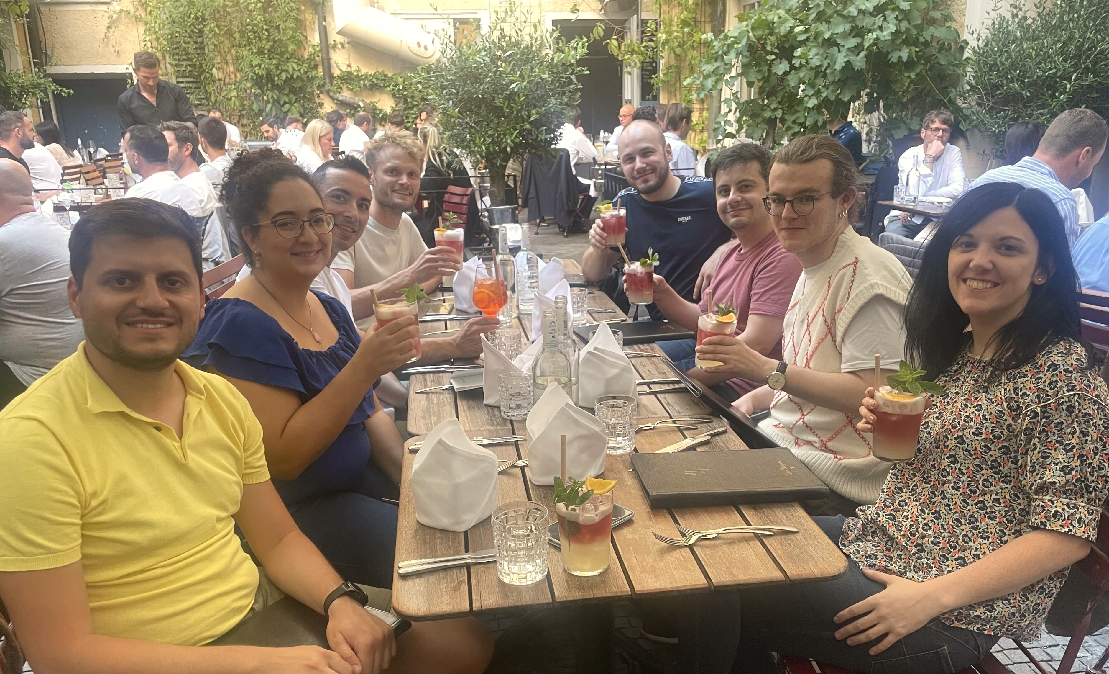 Small group of Personio engineers seated around an outdoor table for dinner.